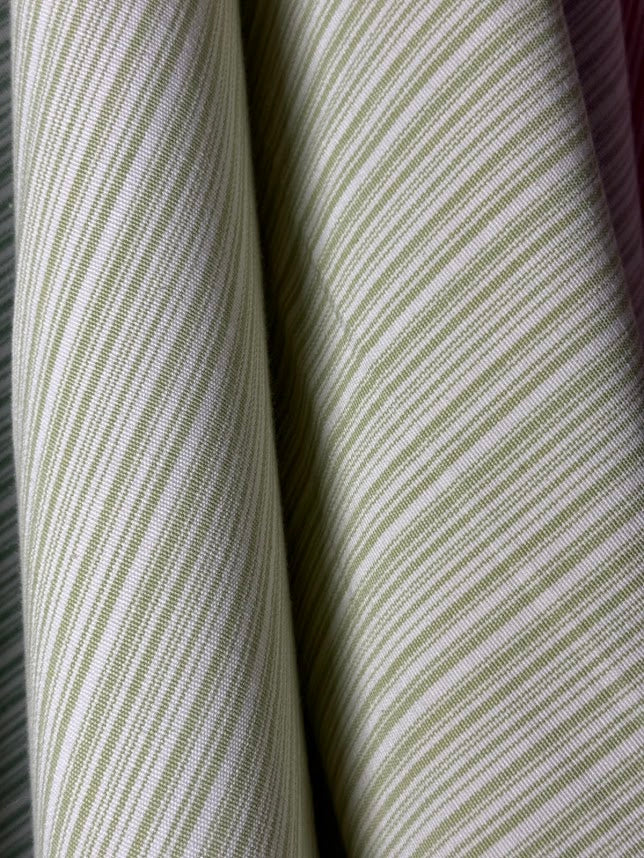 Close-up of striped fabric with green and white lines.