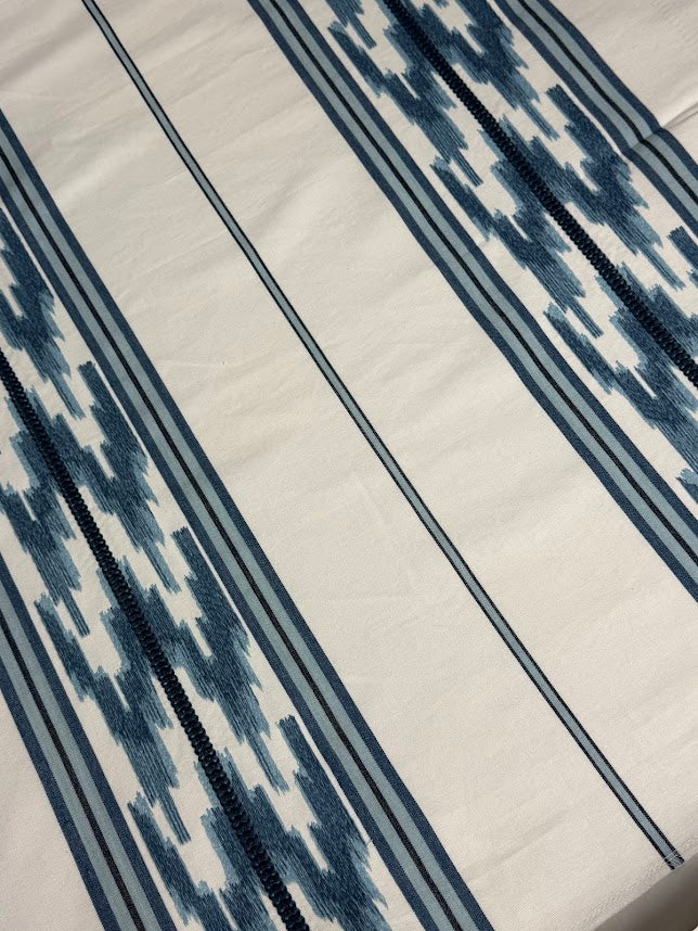 close up of blue embroidered stripe pattern with a geometric design.