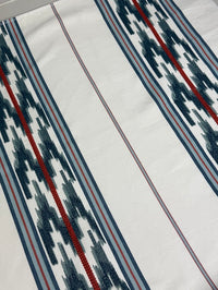 fabric featuring a striped pattern with embroidery in blue and red colors.
