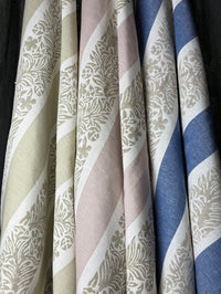 Close-up of fabric swatches with floral striped patterns in various colors.
