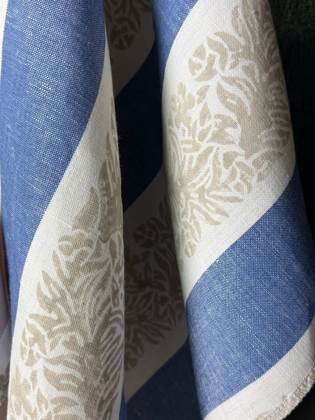 Fabric featuring a striped pattern with leaves in blue, taupe, and tan colors.