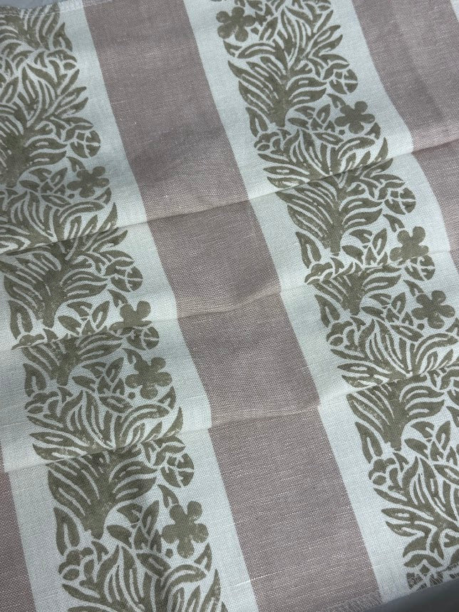 fabric featuring a striped pattern with varying shades of pink, purple, and white colors, with a leaf print design.