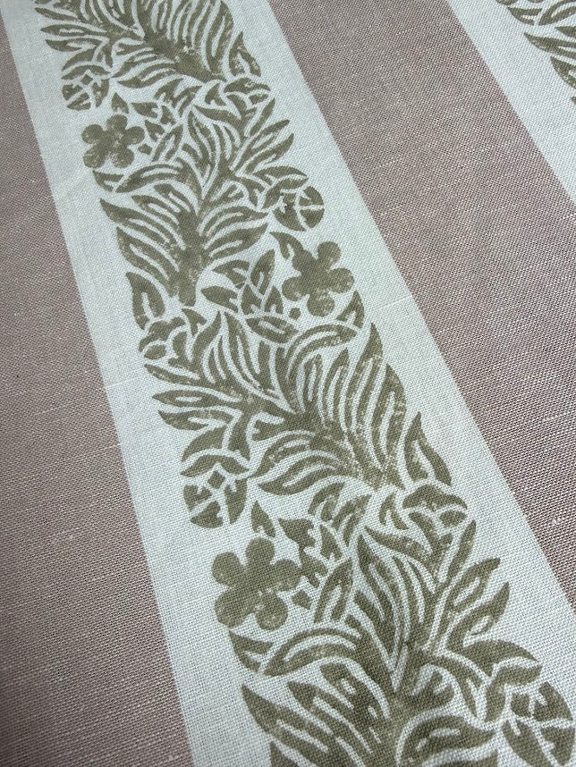 fabric featuring a striped pattern with varying shades of pink, purple, and white colors, with a leaf print design.