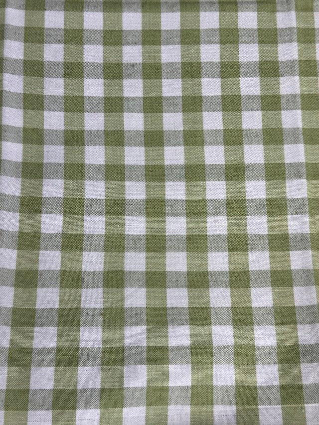 A close-up view of a fabric with a small checkered pattern in light green color.