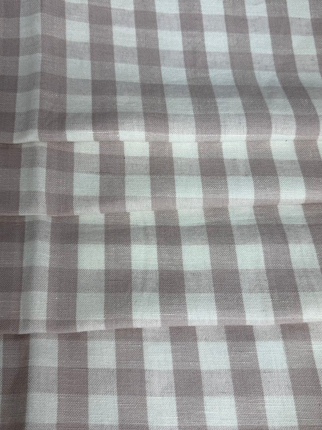A close-up view of a fabric with a small checkered pattern in shades of lavender and purple.