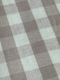 A close-up view of a fabric with a small checkered pattern in shades of lavender and purple.