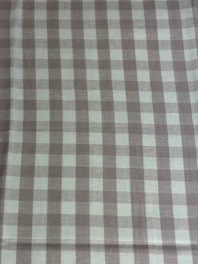 A close-up view of a fabric with a small checkered pattern in shades of lavender and purple.