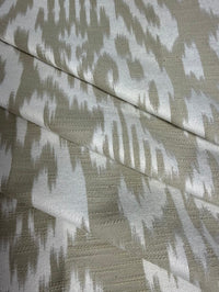 Fabric featuring a beige and cream damask pattern.