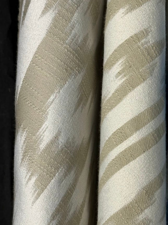 Fabric featuring a beige and cream damask pattern.