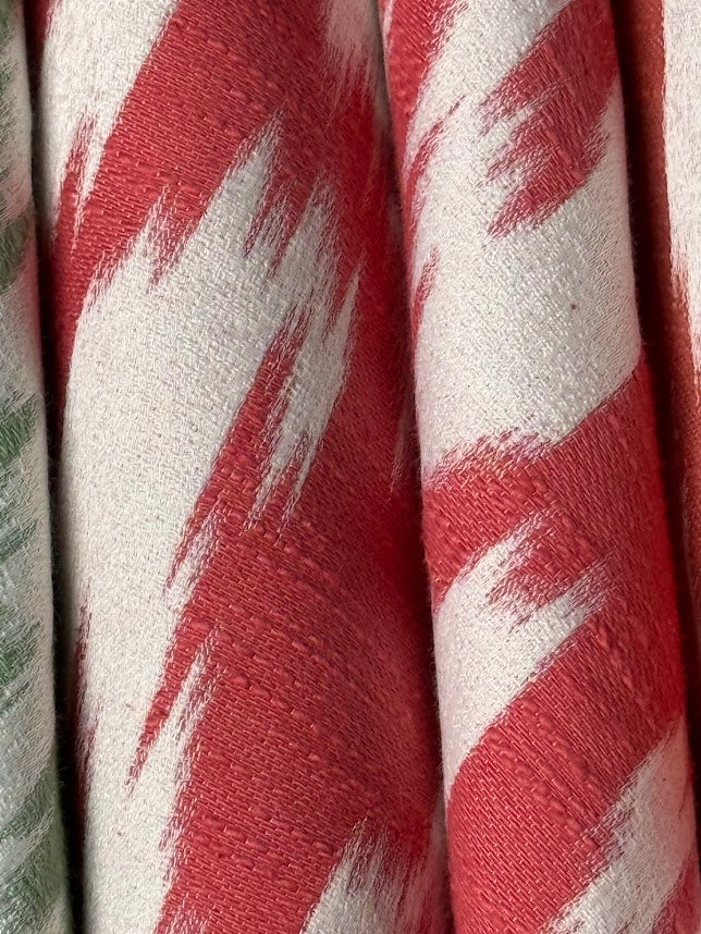 fabric featuring a red and cream damask pattern.