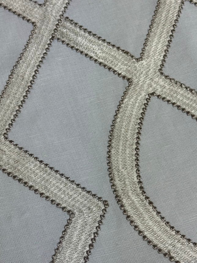 close up of fabric featuring a geometric pattern with beige and white colors.