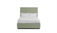 Green upholstered bed with white bedding on a white background