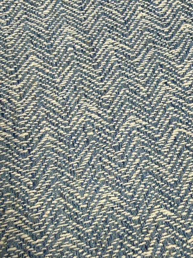 Textured fabric with a herringbone pattern in blue and white.