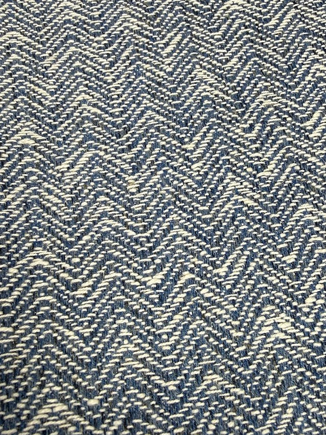 Close-up of a blue and white herringbone patterned fabric.
