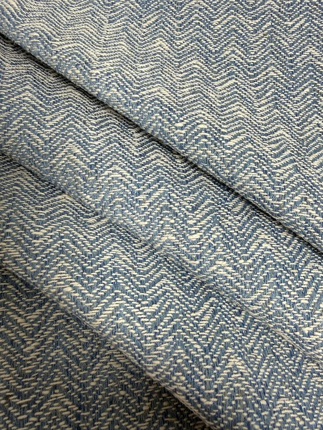 Close-up of blue herringbone fabric with a visible pattern