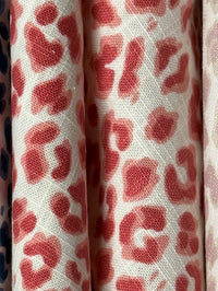 Close-up of fabric with red leopard print pattern on a white background