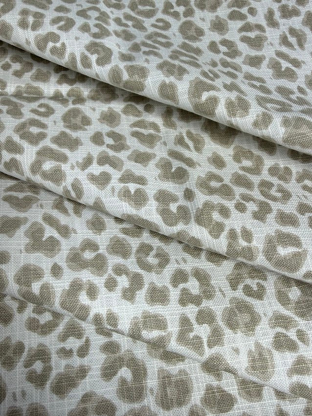 Leopard print fabric with beige spots on a white background