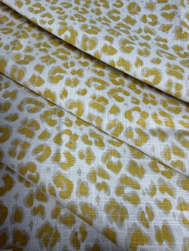 Leopard print fabric with yellow spots on a white background