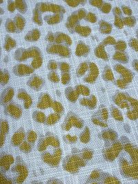 Textile with a gold leopard print pattern on a white background