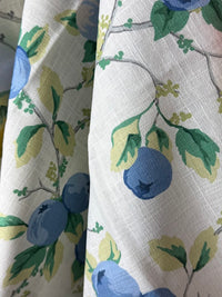 Fabric with blue fruit and green leaves pattern on a white background