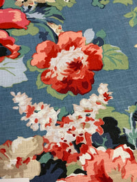 Close-up of a floral fabric pattern with red, white, and green flowers on a blue background.