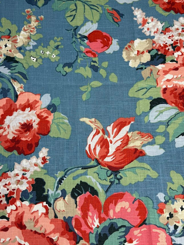 Floral patterned fabric with red, white, and green  on a blue background