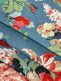 Floral fabric pattern with red, white, and green flowers on a blue background