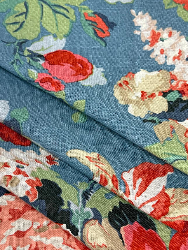 Floral fabric pattern with red, white, and green flowers on a blue background