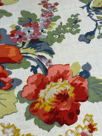 Close-up of a floral fabric pattern with red, yellow, and green flowers on a white background.
