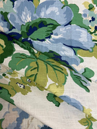 fabric featuring a floral pattern with large blue flowers and green leaves on a white background.