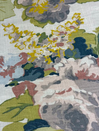 close up of a fabric with a large floral pattern featuring colors such as lavender, purple, green, pale blue, and pink.