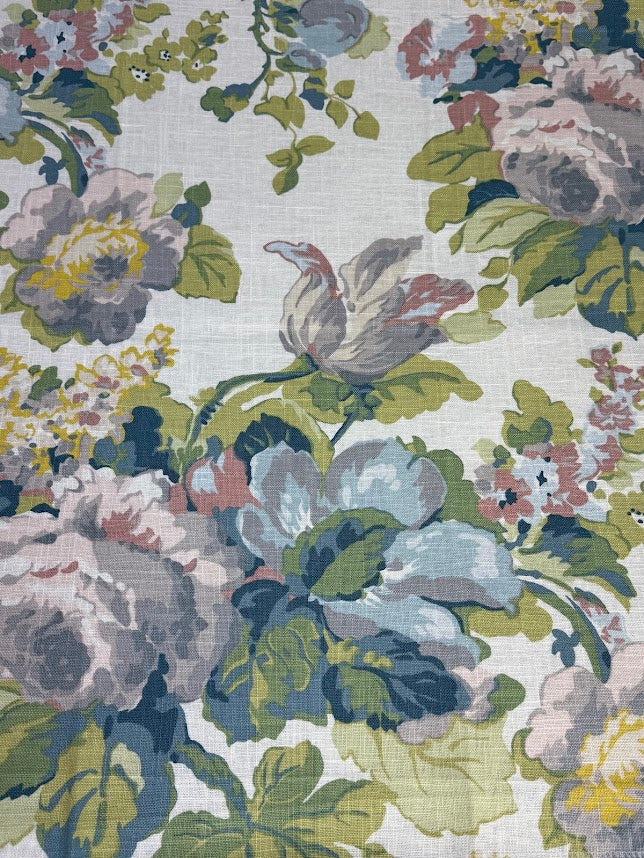 A fabric with a large floral pattern featuring colors such as lavender, purple, green, pale blue, and pink.