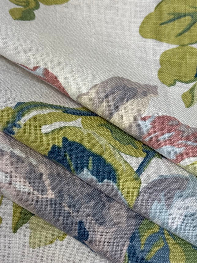 A fabric with a large floral pattern featuring colors such as lavender, purple, green, pale blue, and pink.
