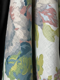 A fabric with a large floral pattern featuring colors such as lavender, purple, green, pale blue, and pink.