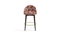 stool in fabric featuring a large-scale geometric pattern with flame stitch design in pink and red colors.