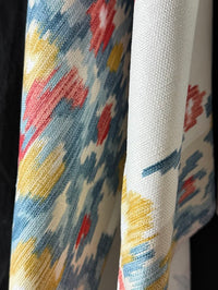 Close-up of fabric with colorful abstract pattern on a plain background
