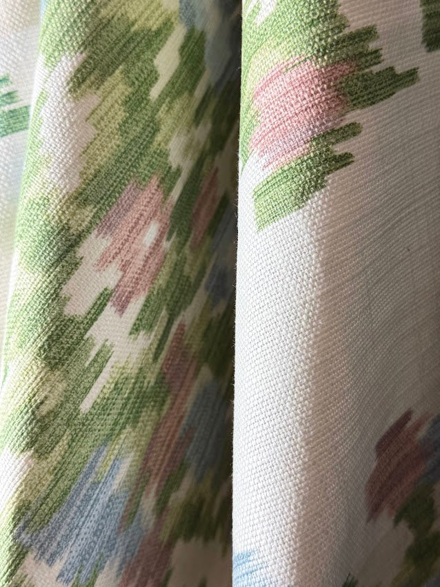 Close-up of floral fabric with green, pink, and blue colors.
