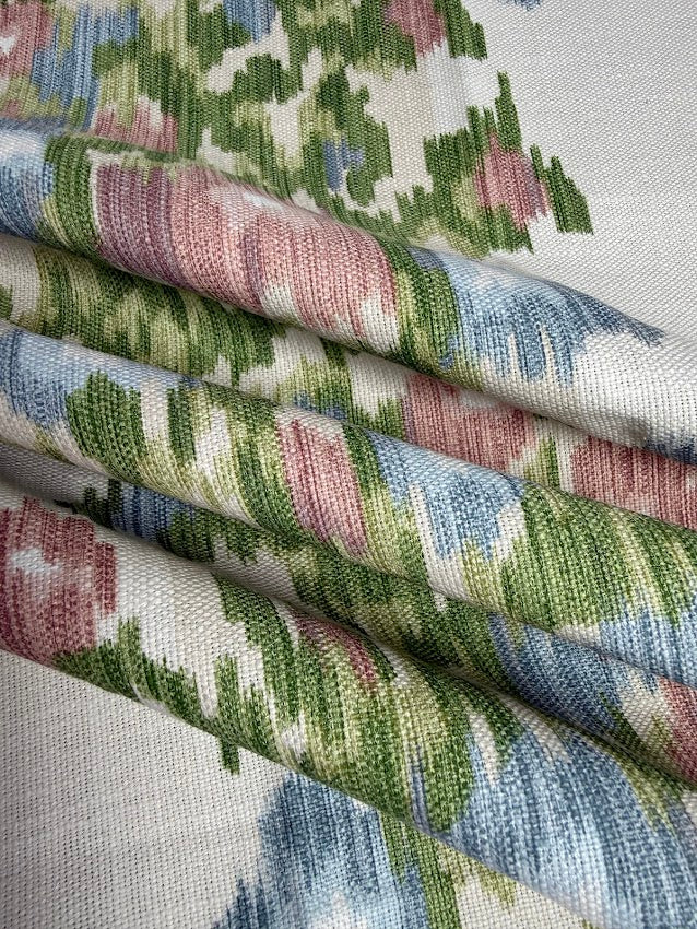 Close-up of patterned fabric with green, pink, and blue colors.