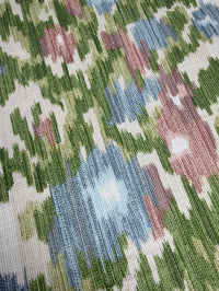 Close-up of a fabric with a geometric pattern in green, blue, and pink.