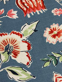 Close-up of floral patterned fabric with red, white, and green flowers on a blue background.