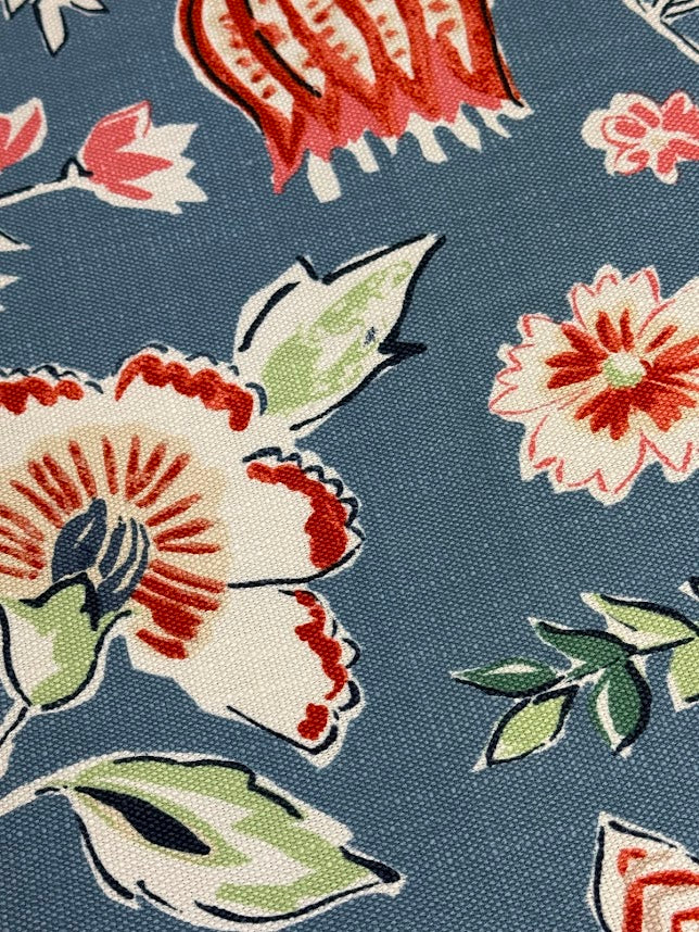 Close-up of floral patterned fabric with red, white, and green flowers on a blue background.