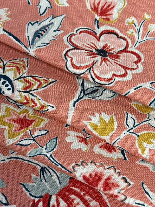 Floral fabric pattern with pink and red flowers on a coral background