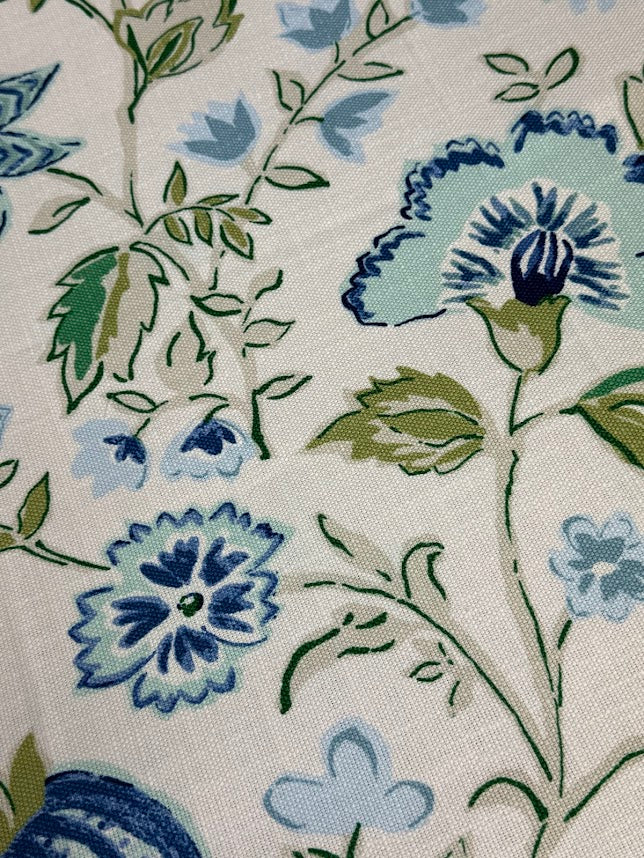 Close-up of floral fabric pattern with blue and green flowers on a white background