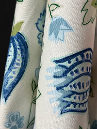 Close-up of fabric with blue and green floral patterns on a white background