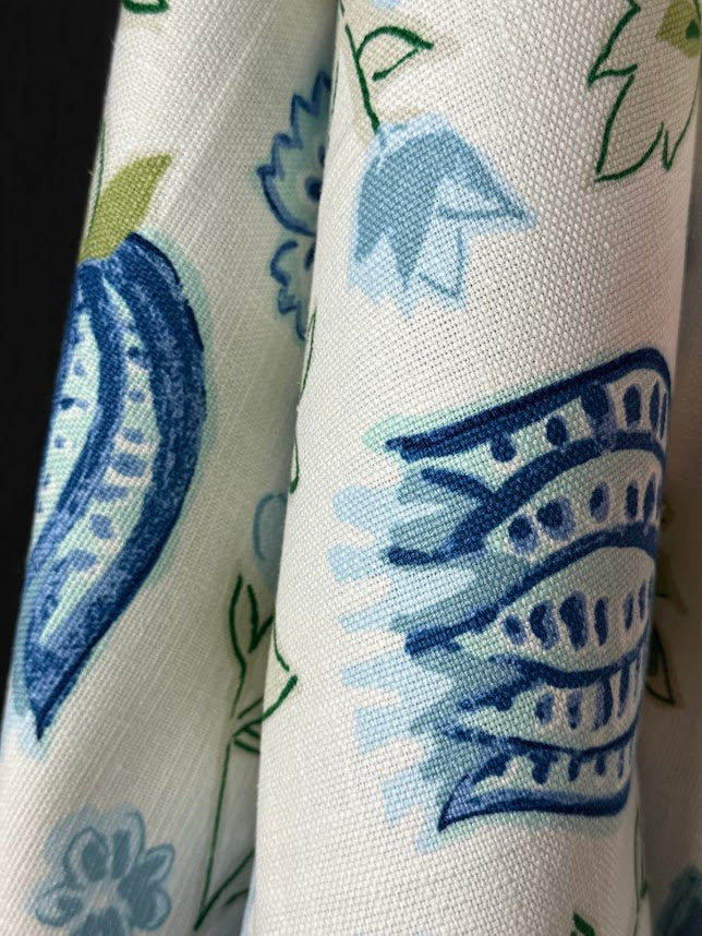 Close-up of fabric with blue and green floral patterns on a white background