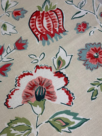 Close-up of floral fabric pattern with red, white, and green colors on a beige background.