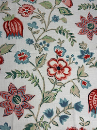 Close-up of floral fabric pattern with red, blue, and green flowers on a white background
