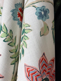 Close-up of floral fabric with blue, green, and red colors on a white background.