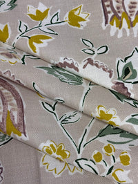 Floral patterned fabric with yellow flowers and green leaves on a beige background