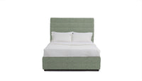 Green upholstered stanford bed with white bedding on a white background
